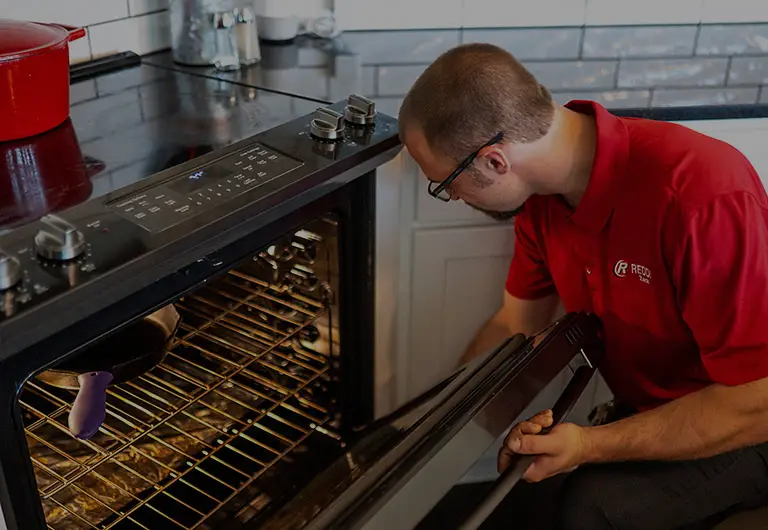 Appliance Repair Technician Working on an Oven
